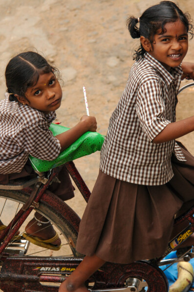 Indian schoolgirls sit on a bicycle