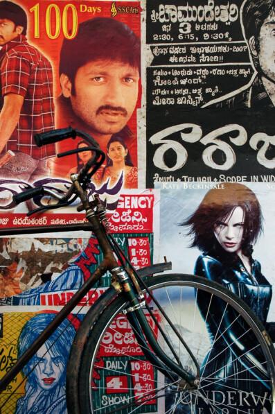 An Indian bicycle is leaned against movie posters