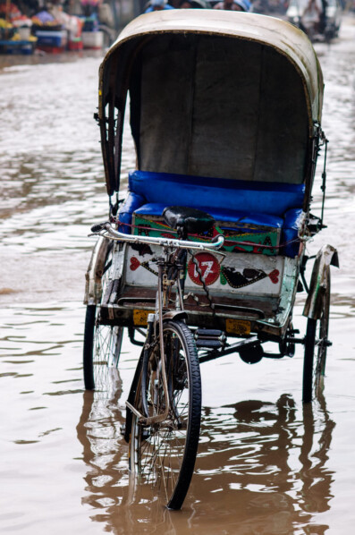 A rickshaw stands in a flooded street in India