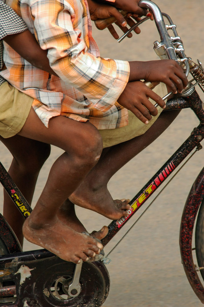 Two boys sit on a bicycle in India
