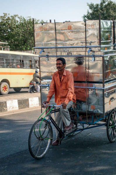 A rickshaw loaded with met cans in India
