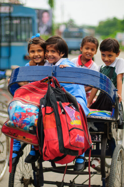 A rickshaw is loaded full of school children in India.
