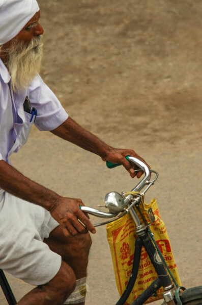 An elderly Sikh pedals his bike