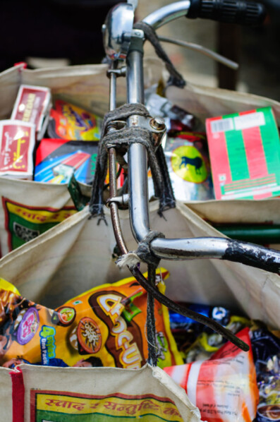 Shopping bags are hung over bicycle handlebars in Nepal.