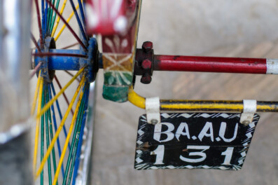 A brightly painted rickshaw wheel and license plate in Nepal
