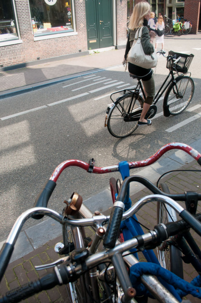 Amsterdam cyclist rides through a street.