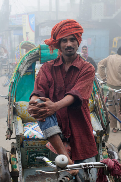 A Bangladesh chauffeur sits in his rickshaw