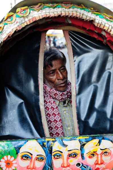 A Bangladesh peers through a rickshaw awning