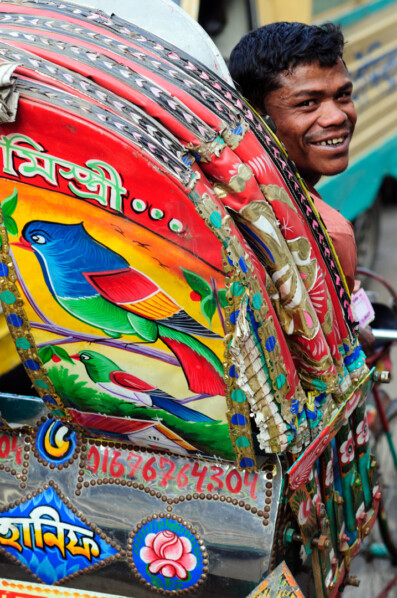 A Dhaka rickshaw chauffeur laughts