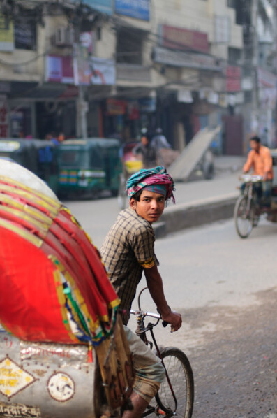 A Dhaka rickshaw chauffeur glances back