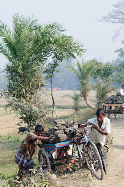 Bangladesh men push van rickshaws loaded with heavy clay