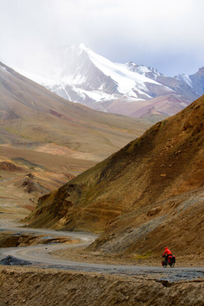 A red bike heads down Ak Baital pass on the Pamir highway.