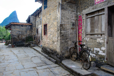 A bicycle leans against a traditional house in China
