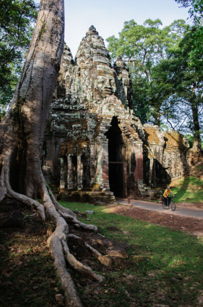 A cyclist heads through an archway in Angkor Wat Cambodia.