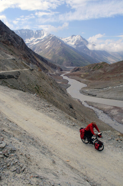 A fully loaded touring cyclist heads up Kunzum La Pass in the Indian Himalaya