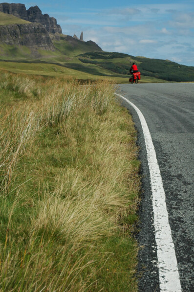 A touring cyclist heads up a hill in Scotland.