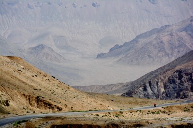 A little red cyclist heads down the Pamir highway.