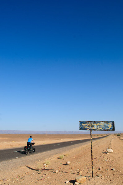 A blue cyclist heads into the desert in Southern Morocco