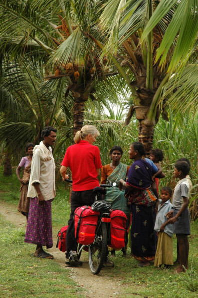 A western touring cyclist is asked questions by friendly locals in South India.