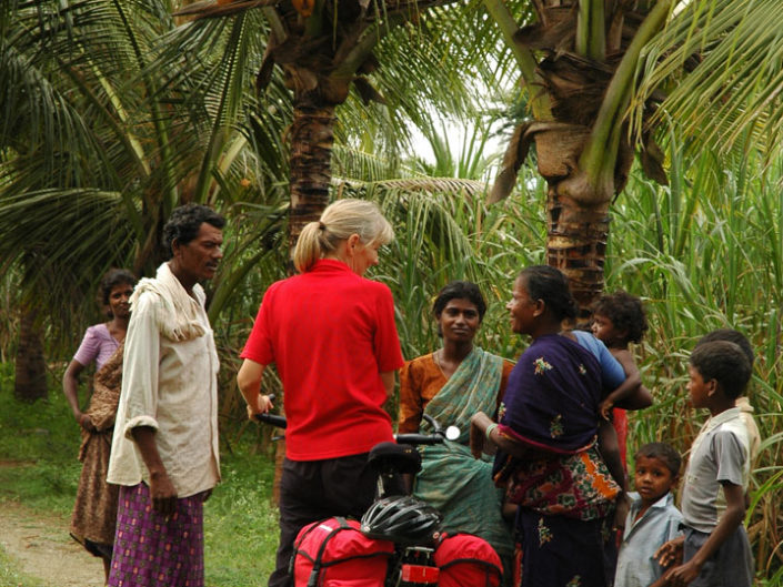 A western touring cyclist is asked questions by friendly locals in South India.