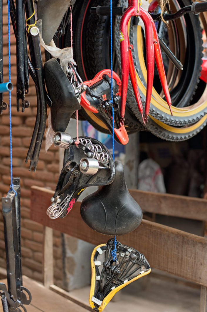 Bicycle saddles plus tires hang in an African bike shop.