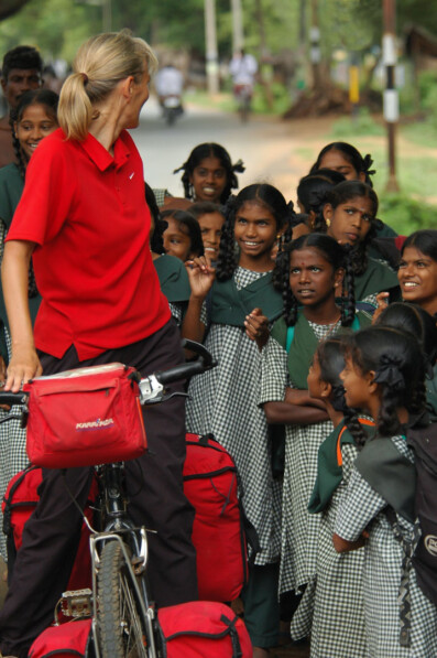 Curious Indian schoolgirls question a female western bicyclist during her bicycle tour of Southern India.