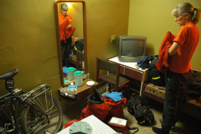 A touring cyclist stands in an Indian hotel room.