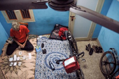 A touring cyclist sits in a hotel room playing cards in India.
