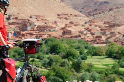 A touring cyclist looks out over a village in Morocco
