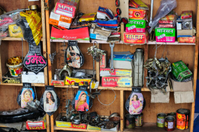 The back shelf of a Kathmandu bike shop is filled with bicycle parts and mud flaps portraying Bollywood film stars.