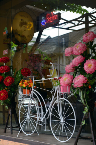 A white bicycle decoraes a store window in Thailand