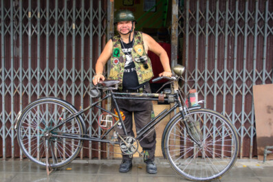 A Bangkok man stands proudly behind his decorated bicycle in Thailand.