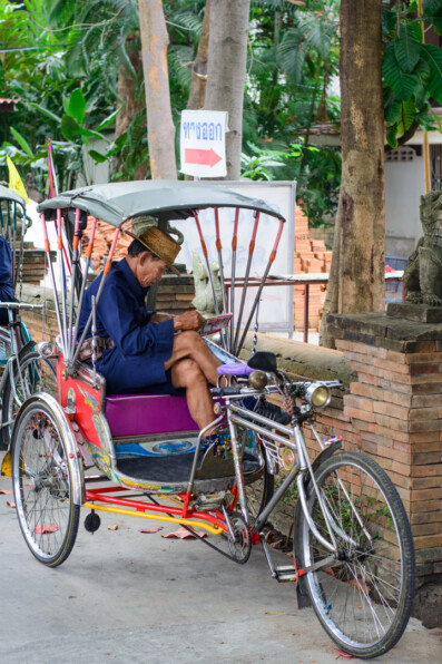 A rickshaw chauffeur waits for passengers in Thailand