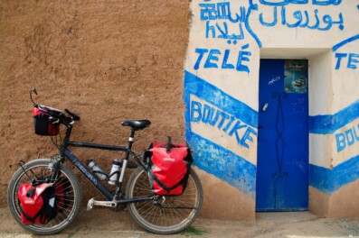 A fully-loaded touring bicycle is leaned against a wall in Morocco