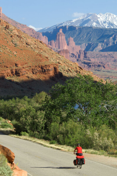 Cycling towards Moab, Utah with a view of Fisher Towers.