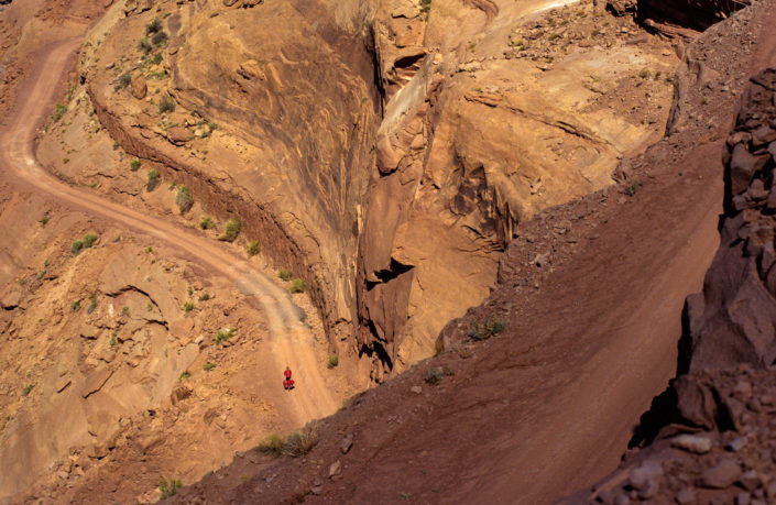 A little red cyclist rides down the Mineral Canyon road