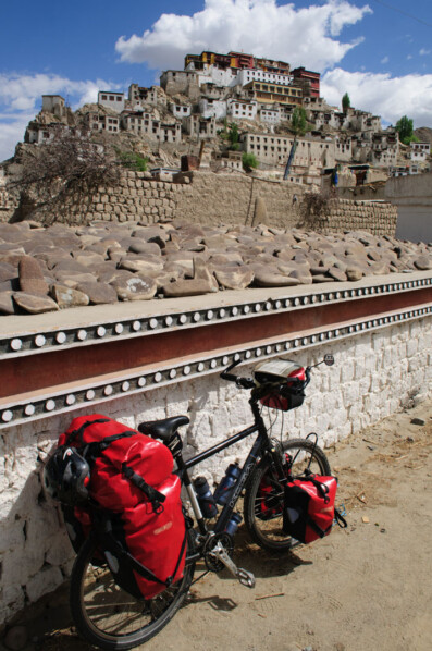 A touring bicycle is leaned against a wall near Thiksey Monastery in North India.