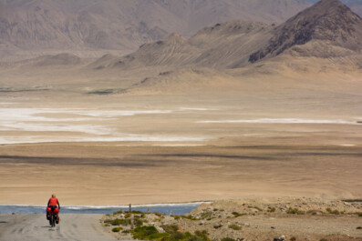 Cycling through the desert landscape of the Pamir highway in Tajikistan.
