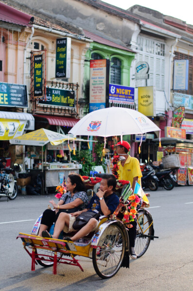 Tourists take a rickshaw tour of Penang, Malaysia