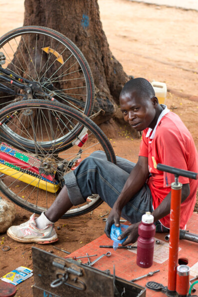 An Africna bicycle repair man fixes a bike wheel