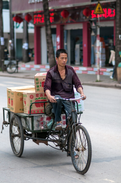 A Chinese man rides a cargo bike