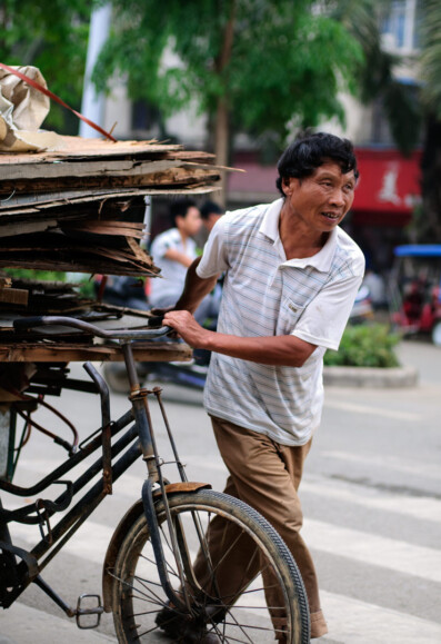 A Chinese man pushes a fully loaded cargo bike in China