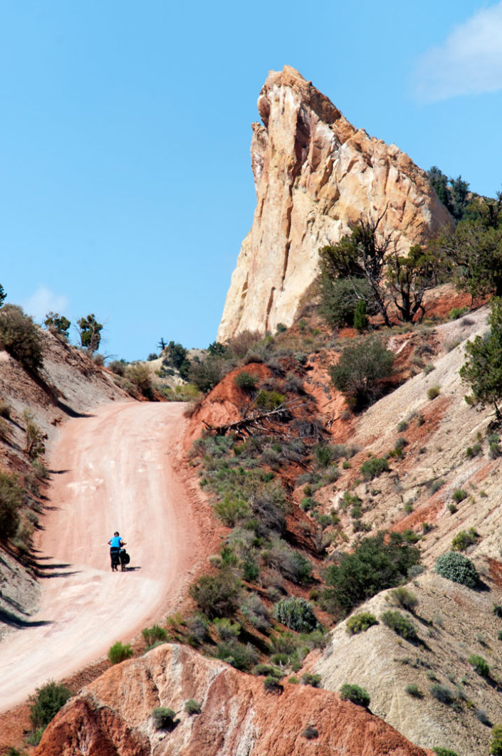 Pushing a touring bike up a steep hill in Utah's painted desert