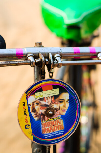 A music cd hangs from bicycle handlebars in India
