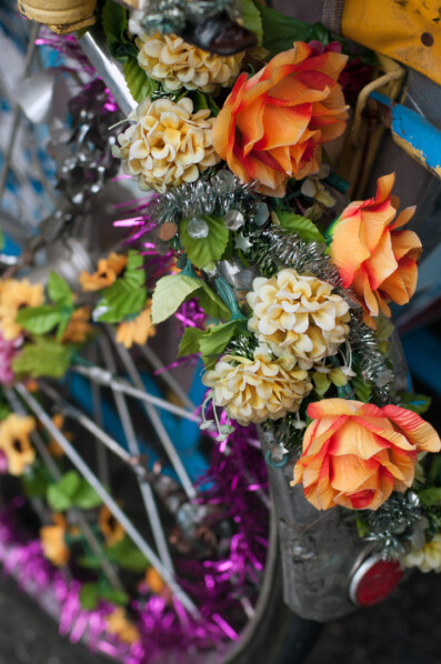 A rickshaw wheel in Penang, Malaysia is decorated with flowers