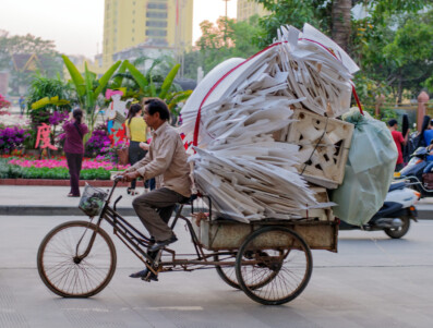 A Chinese man pedals his cargo tricycle full of styrofoam