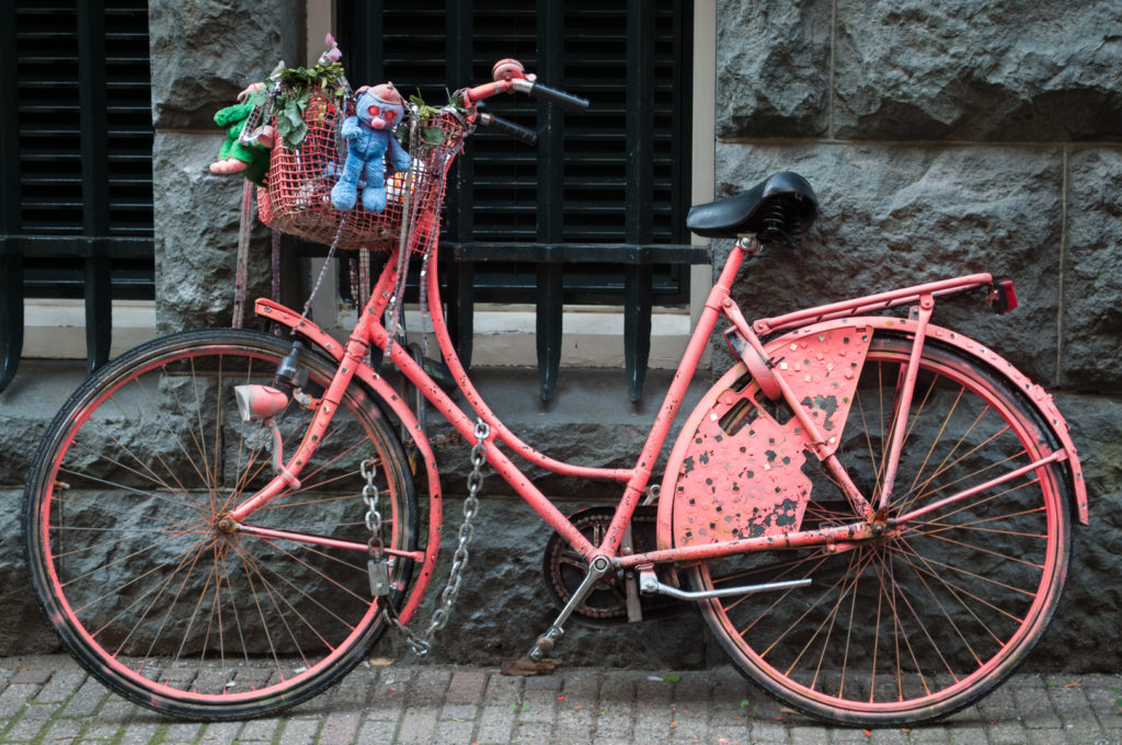 Bicycle culture - a pink painted bicycle with decorations attached to the bike basket.