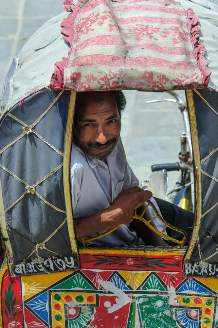 A chauffeur sits in his rickshaw in Nepal.