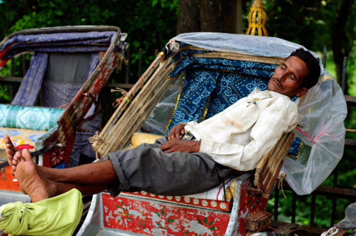A chauffer takes a nap in his rickshaw in Nepal.
