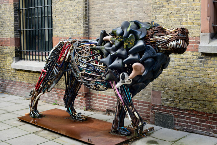 a statue of a lion that is made from old bicycle parts.